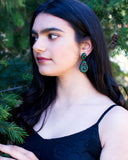 Black and green statement earrings with LBD