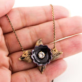 Antique style necklace with black enamel flower and brass leaves